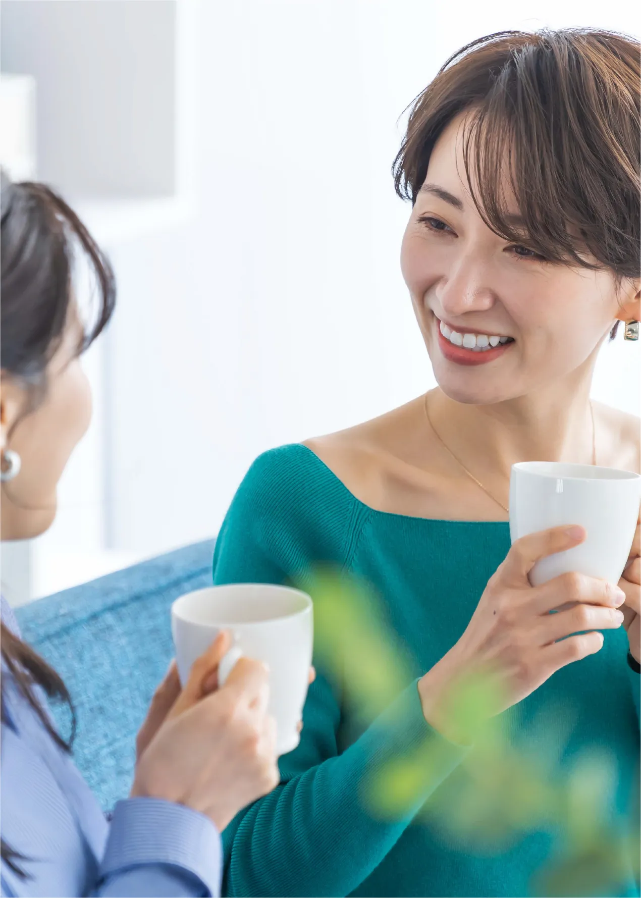 カップを持って話す女性の写真
